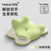 The image shows the NeLar Bed Lie Down Pillow, a soft, ergonomic green and beige memory foam pillow with a wavy shape. It features Chinese text, an illustration of someone hugging it, and serves as a leg or backrest pillow for sleeping or reading.
