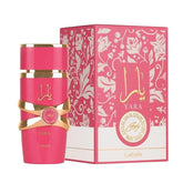A 100ml Lattafa Yara Candy Vanilla Fruity Citrus Floral Eau de Parfum by Showlu Well Nation Store stands beside its matching pink and gold box, featuring floral designs, Arabic script, and hints of a long-lasting floral fragrance.