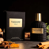 A black and gold bottle labeled "3.4 Fl Oz Men's and Women's Eau De Parfum, Mandarin Orange, Orange Blossom & Bergamot" stands by its box, exuding a festive fragrance—an ideal Christmas gift inspired by elegant traditions.