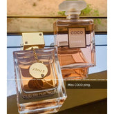 Two perfume bottles on a reflective surface: Showlu Well Nation Store’s Miss Coco stands upright, while Armaf Amafu Nightclub with the Same Name Perfume for Women sample lies down. The text overlay reads, “Miss COCO ping.”.