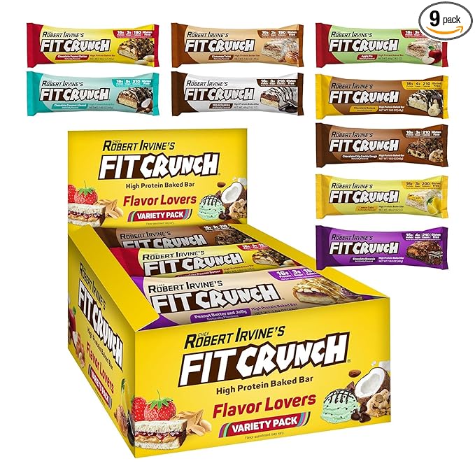 A yellow box of Showlu Well Nation Store's FITCRUNCH Snack Size Protein Bars, 6-Layer Baked Bar (Flavor Lovers, 9 count), is displayed with vibrant packaging highlighting its gluten-free, low sugar, soft cake core snacks.
