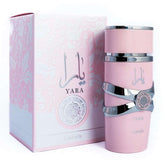 A pink Lattafa Yara for Women Eau de Parfum Spray (3.40 oz/100 ml) from Showlu Well Nation Store, with silver accents, sits beside its floral-patterned decorative box featuring Arabic script—a sophisticated fragrance for women.