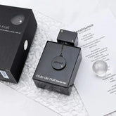 A black bottle of Showlu Well Nation Store's Napoleon's Level for Armaf Club De Nuit Amafu Nightclub Carnival Men Perfume Genuine Goods sits on a white textured surface, beside its box, a printed sheet, and a clear glass sphere.
