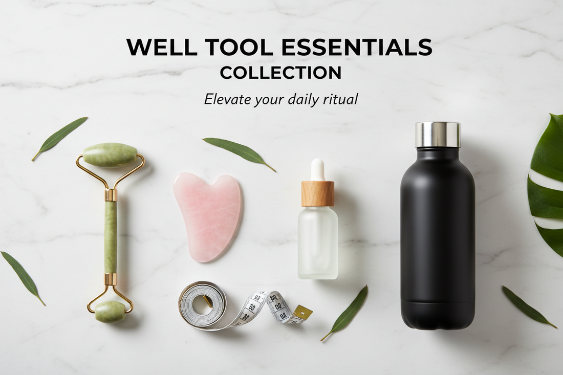 Flat lay of wellness tools on marble: jade roller, gua sha stone, dropper bottle, tape measure, and black water bottle, with green leaves and text “Well Tool Essentials Collection.”.