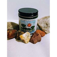Nature's Blessings Hair Pomade jar surrounded by natural stones for hair restoration.