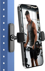 A smartphone on a blue metal surface is held by the APPS2Car Magnetic Phone Holder for Gym, featuring an alloy base, strong hold, and 360° adjustability; it displays a man lifting a barbell in a gym.