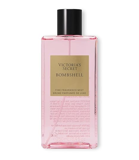 A rectangular clear pink 8.4oz bottle of Bombshell Fine Fragrance Mist by Showlu Well Nation Store, with a black cap and gold label, features the product name and delivers a signature fruity floral scent.
