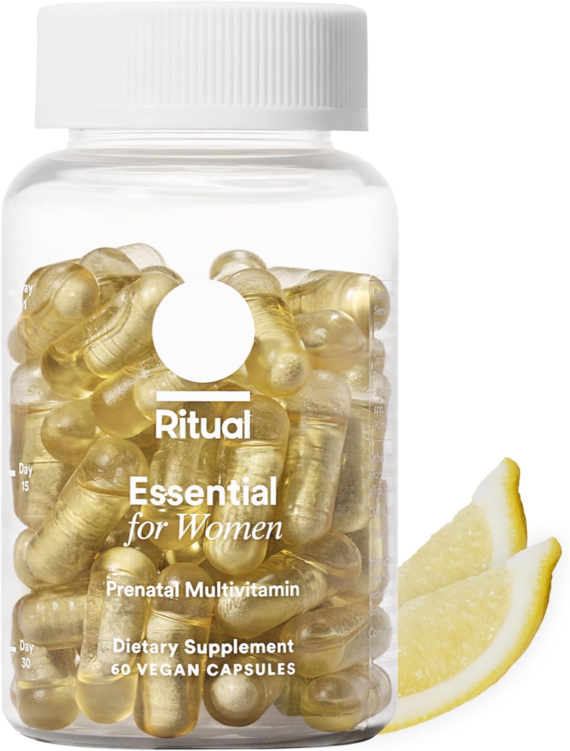 A clear bottle labeled Ritual Essential for Women Prenatal Multivitamin: Folate & Choline for Neural Tube Support, Omega-3 DHA for fetal brain development, Non-GMO, Vegan, Citrus (30 Days), sits by two lemon slices with yellow capsules inside.