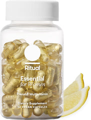 A clear bottle labeled Ritual Essential for Women Prenatal Multivitamin: Folate & Choline for Neural Tube Support, Omega-3 DHA for fetal brain development, Non-GMO, Vegan, Citrus (30 Days), sits by two lemon slices with yellow capsules inside.