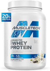 A white container of Muscletech Grass-Fed Whey Protein Powder (Deluxe Vanilla, 1.8LB) offers 20g protein per serving to support muscle gain and recovery. It’s non-GMO, gluten-free, has no artificial colors or flavors, with vanilla flowers on the label.
