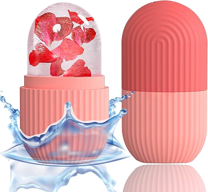 Two pink, capsule-shaped XHJRI Ice Cube Roller Massagers for face, eyes, and neck; one open to reveal red petals inside a transparent dome—ideal for reducing under eye puffiness and migraine pain. A splash of water surrounds the open container.