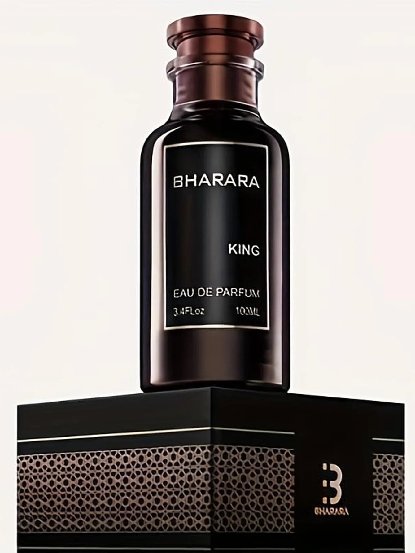 A dark brown bottle labeled Bharara King Eau de Parfum for Men sits on a black and gold patterned box with a stylized B logo. It features a citrus amber scent, ideal for confident daily wear and evening sophistication.