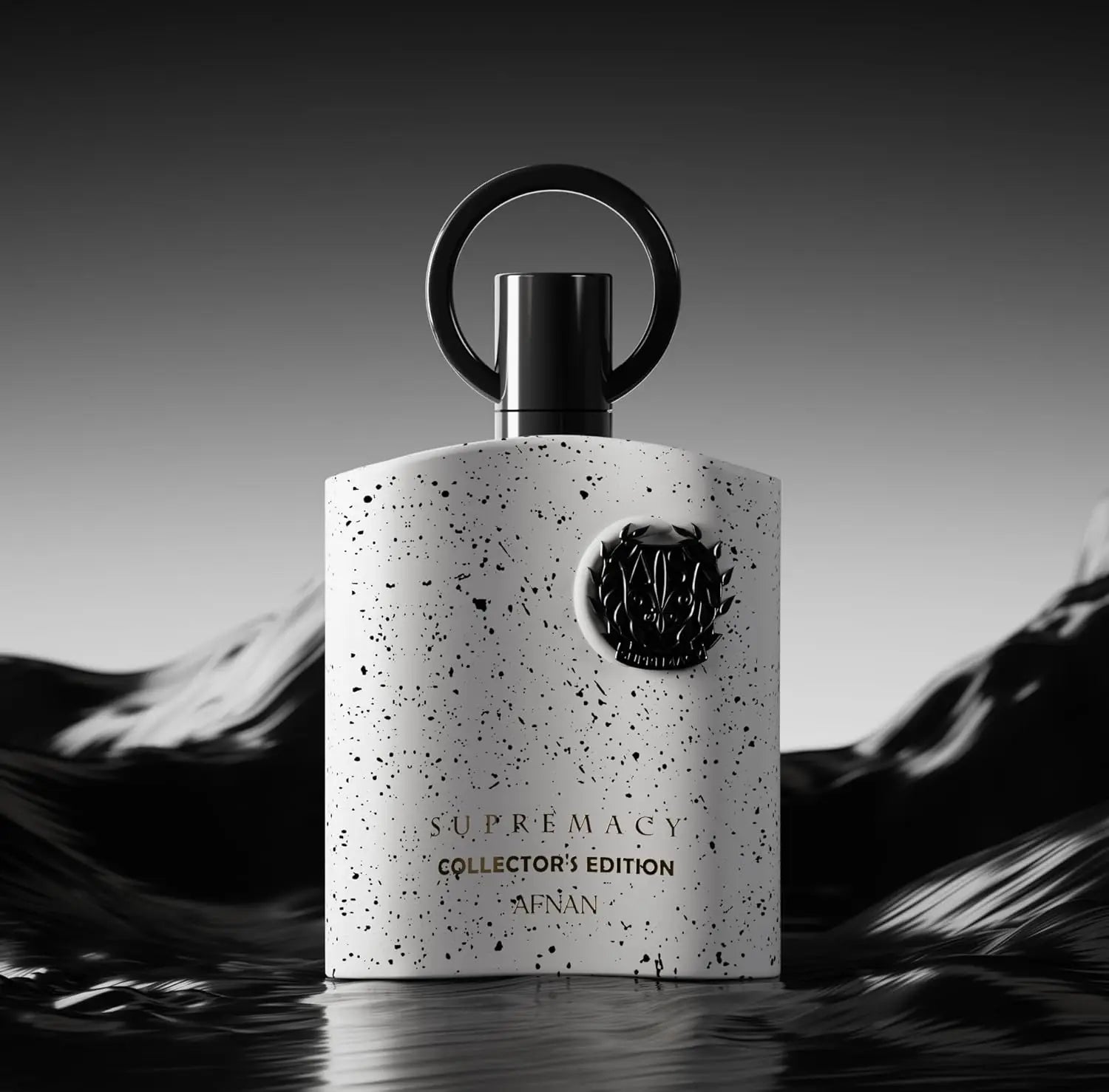 A white perfume bottle with black speckles and a round black cap stands upright against a wavy, dark background. The fragrance is Afnan Supremacy Collector's Edition for Men Eau De Parfum, 3.4 Fl. Oz, labeled in gold and black text.
