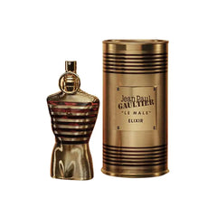 A gold, torso-shaped bottle stands beside a matching cylindrical case labeled Le Male Elixir by Jean Paul Gaultier Men's 4.2 oz perfume spray—both with metallic stripes and a glossy finish, representing this iconic men's fragrance.