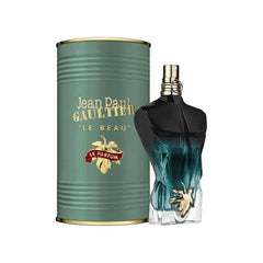 Jean Paul Gaultier Les Males De Le Beau Le Parfum Eau De Parfum Powerful Perfume 125ml comes in a green cylindrical box with gold text, alongside a torso-shaped bottle with a gold and blue gradient and gold leaf detail—an alluring unisex fragrance.
