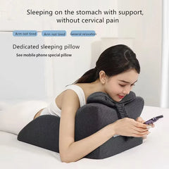A woman relaxes on her stomach using the Lie On The Bed Sleeping Pillow, an ergonomic memory foam cushion that supports her head, chest, and arms—reducing cervical pain and providing essential arm support for comfortable phone use.