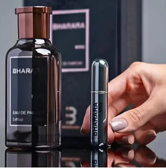 A hand holds a small metallic spray bottle beside a large Bharara King Eau De Parfum 100ml for men, both with precise craftsmanship, set against blurred Mainland China packaging.