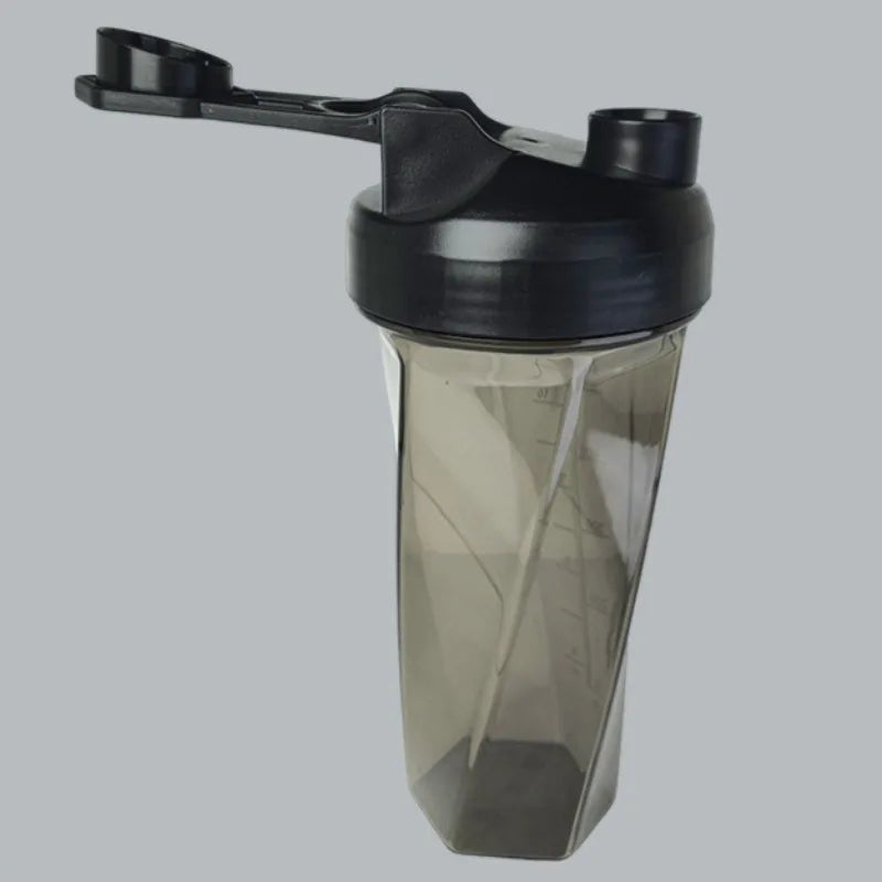 The 600ml Vortex Mixer Shaker Bottle for Protein Shakes, made from high-quality TRITAN, features a transparent hexagonal design with a black flip-top lid and carrying loop—an essential sports water bottle for the gym.