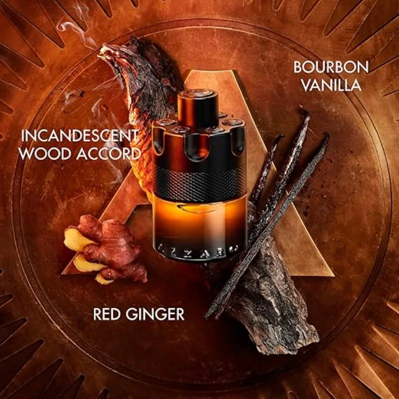 An amber bottle of Azzaro The Most Wanted Parfum Intense 100ML, a long-lasting fragrance, sits amid wood, vanilla beans, and red ginger. Text features Incandescent Wood Accord, Bourbon Vanilla, and Red Ginger on a bronze background.