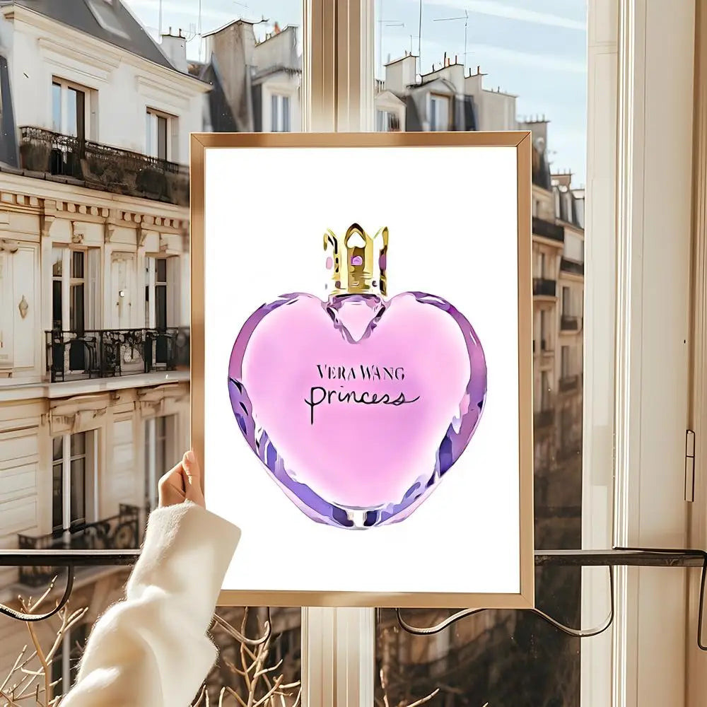 A hand displays a framed "Perfume Bottle Prints Nordic Poster"—a modern wall art sticker featuring a heart-shaped bottle—by a window with Parisian views, perfect for home decor in living rooms, bedrooms, or bars.
