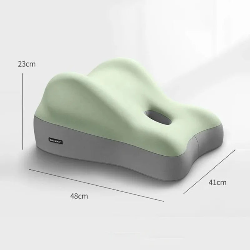 The Multi-Functional Ergonomic Bed Pillow is a light green and gray memory foam cushion with a wave-like design, central hole for neck support, 48x41x23 cm, and features a soft 100% cotton cover. Ideal as a waist or tummy pillow.