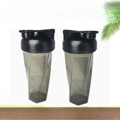 Two translucent, smoky gray Vortex Mixer Shaker Bottles for protein shakes, made from high-quality PC material, feature black lids with flip caps. Side by side on a light background, the left bottle shows measurement marks and highlights a chemical-free design.