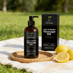 A bottle and box of Anti Cellulite Oil Firm Skin Tightening Massage Oil with lemon and grapefruit essential oils rest on a woven tray atop a picnic blanket, surrounded by fresh lemons in a sunny outdoor scene.