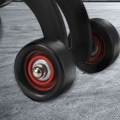 Close-up view of two black and red wheels attached to the 1pc Abdominal Exercise Wheel—Four Wheels for Stability—ideal home gym fitness equipment for strengthening core and toning abs on a textured gray surface.
