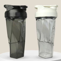 Two 600ml Vortex Mixer Shaker Bottles made from high quality TRITAN are displayed side by side—one with a black lid, one with a white lid. Featuring geometric designs, they’re perfect gym essentials for mixing protein shakes. Both rest on a round white surface.