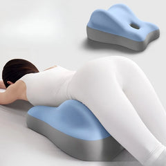 A person in white lies face down on the Multi-Functional Ergonomic Bed Pillow, a blue and gray memory foam wedge-shaped cushion that supports the hips and pelvis. An additional image displays its contoured shape and center hole.