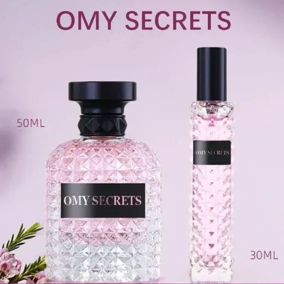 Two pink, textured glass bottles of Miss Adventure Donna Perfume are displayed: a 50ml size with a black cap and a 30ml with a silver cap. Flowers highlight its lasting fresh floral-fruity scent with notes of rose and jasmine. Perfect for daytime wear.