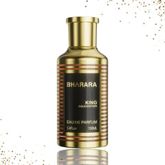 A 100 ml Bharara King Gold Edition Eau de Parfum, inspired by elite gourmand classics, in a gold bottle with black-and-gold labeling against a white background with gold splatters—crafted for long-lasting luxury and distinction.