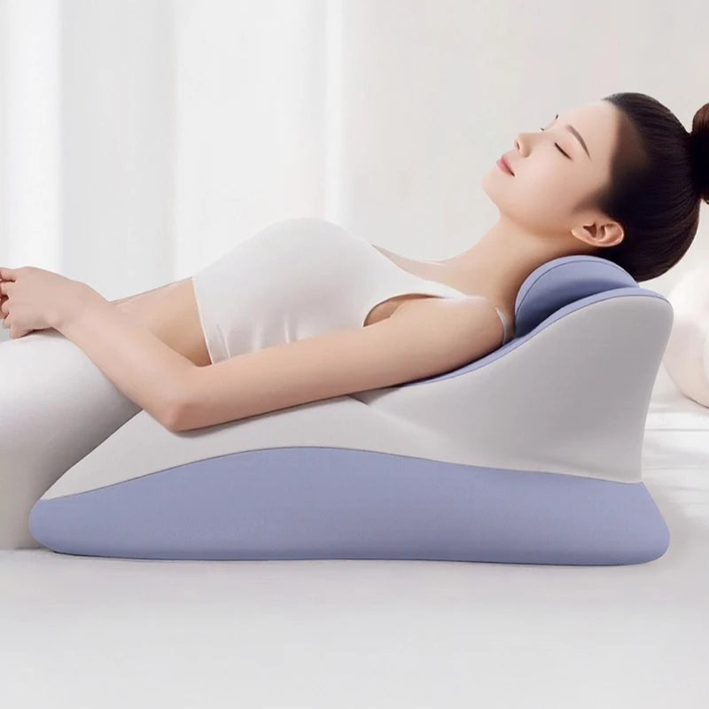 A woman relaxes on the Memory Foam Bed Wedge Pillow, featuring a blue and white design, enjoying head and back support for acid reflux relief, anti-snoring, pain relief, reading comfort, and post-surgery recovery in a bright setting.