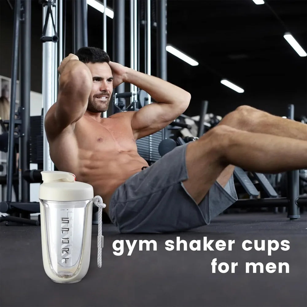 A man in gym clothes does sit-ups on the gym floor with equipment behind him; a Premium Protein Powder Shaker, 590ml/20oz, leak-proof Tritan, BPA-free with mixing ball is in front. Text: Shaker cups for men—see Specifications for details.