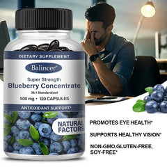 A bottle of Blueberry Capsules - 500 Mg sits beside fresh blueberries. In the background, a tired man rubs his eyes at his desk. Text highlights brain, heart, and eye health benefits, antioxidants, and skin support with 120 capsules per bottle.