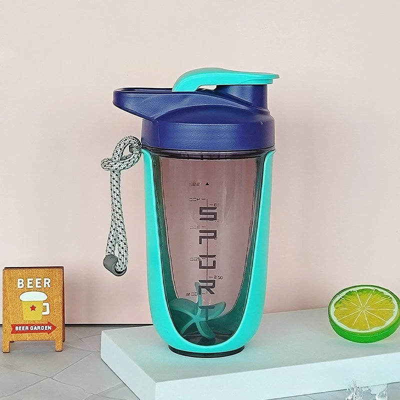 A blue and turquoise 590 ml/20 oz Premium Protein Powder Shaker (leak-proof Tritan, BPA-free, plastic ball) with a handle and markings stands on white; made in China, beside a mini BEER sign (left) and half lime slice (right). Brand: none.