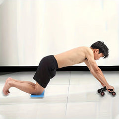 A man uses the 1pc Abdominal Exercise Wheel—featuring four wheels for stability—to strengthen his core and tone abs, performing a waist and abdomen exercise in a bright home gym.