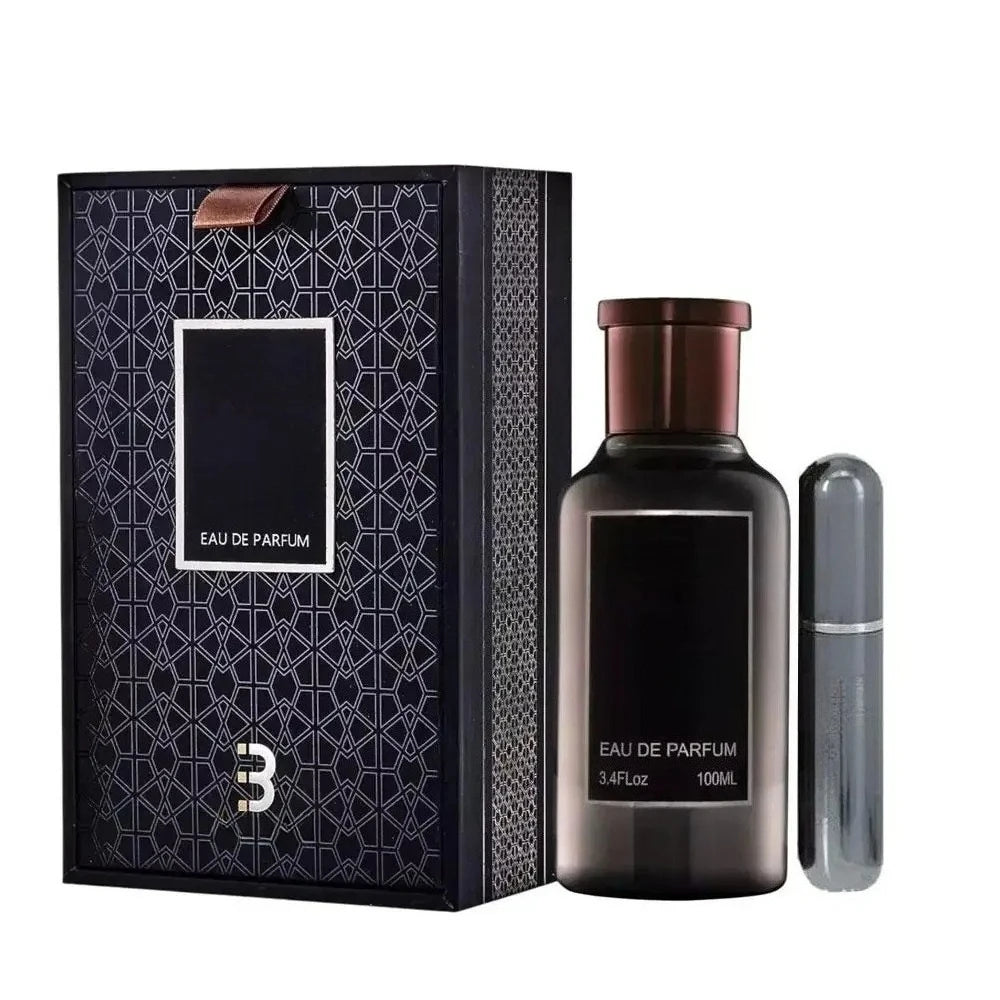 A 100ML Eau De Parfum For Men bottle, labeled 3.4 Oz and sealed in a high-end gift box, stands beside a sleek travel atomizer, creating an elegant presentation for this new woody fragrance.