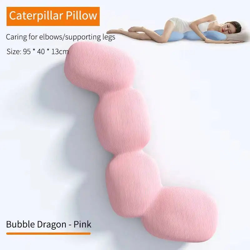 A woman lies on her side using the Memory Foam Hold In Bed Sleeping Body Pillow for Pregnant Women in pink, offering leg and elbow support. It features a removable, washable cover and measures 95 x 40 x 13 cm.