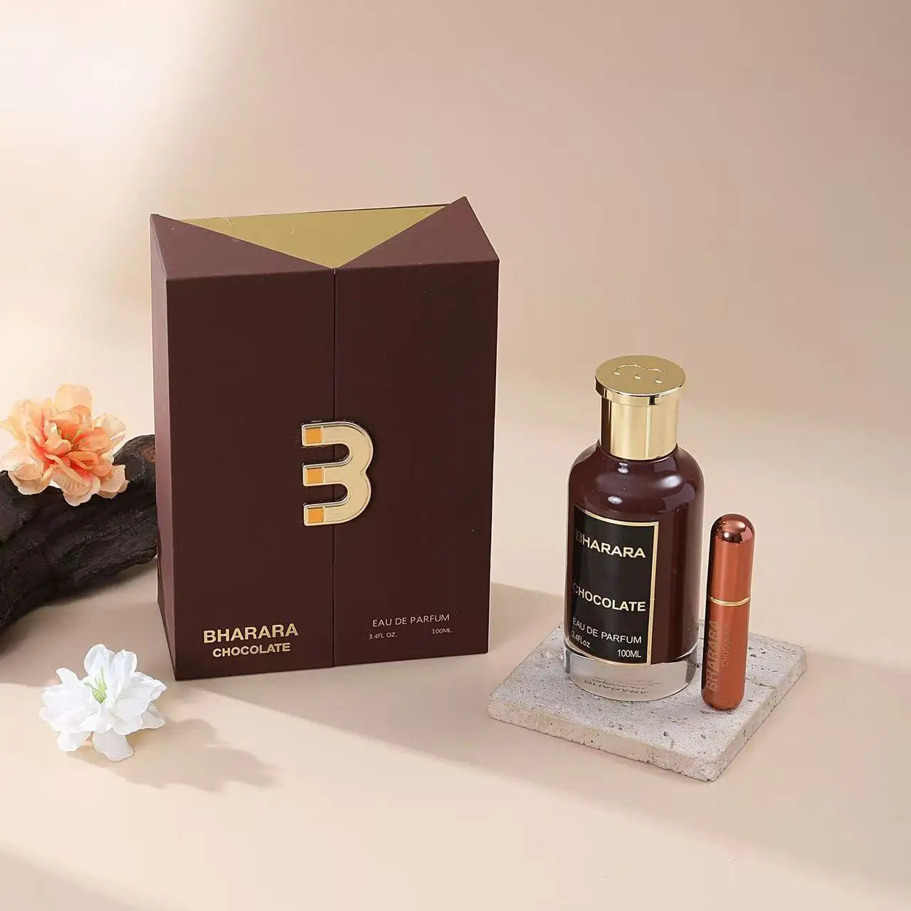 A bottle of Bharara King Men's Eau de Parfum, a rich woody fragrance (100ml), stands on a stone coaster beside its brown and gold box, with a small lipstick and decorative flowers on a neutral background—perfect gift for him.