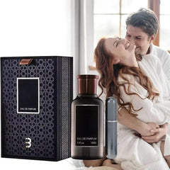 A smiling couple in white robes embrace on a bed near a window, while in the foreground, a black bottle of 100ML Eau De Parfum For Men and its high-end gift box hint at an elegant, luxurious fragrance experience.