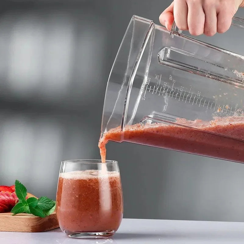 A hand pours a reddish-brown smoothie from the For SILVER CREST Blender Spare Jug (2L, transparent) into a glass. Strawberries, mint leaves, and the blender jug are on a cutting board in the background on a gray surface.