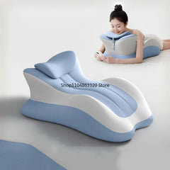 A woman relaxes on the Memory Foam Pillow Ergonomic Support, enjoying bedding-like comfort while using her phone; a second identical wedge-shaped pillow is visible in the foreground.