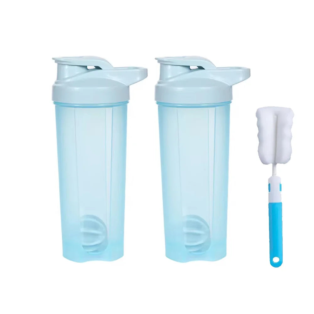 Two translucent blue 28 oz Shaker Bottles for Protein Shakes with light blue flip-top lids are side by side. To their right is a chemical-free white and blue bottle-cleaning brush from Mainland China.