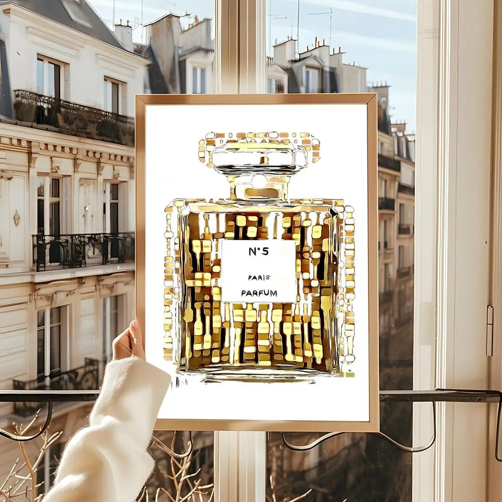 A person holds up the Perfume Bottle Prints Nordic Poster Wall Art, featuring a perfume bottle design, in front of a window with Parisian buildings visible in the background.
