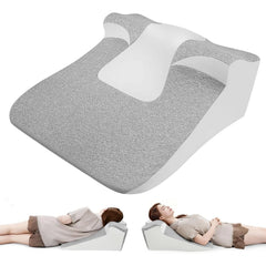 The Bed Wedge Sleeping Pillow for Acid Reflux is a gray and white ergonomic memory foam pillow with a cutout section, shown alone and used by a woman for neck and back support while reading or resting.