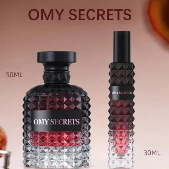 Two Miss Adventure Donna Perfume bottles: a 50 ml round, faceted bottle with large cap and a slimmer 30 ml version, both featuring a black-to-pink gradient and an alluring floral fruity scent of rose and jasmine.