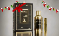 A gold bottle and matching vial of Bharara King Gold Edition Eau de Parfum (100ml), inspired by elite gourmand classics, are shown with a black-and-gold gift box topped with a red bow. Holiday stockings and presents decorate the background.