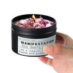 Handheld black tin Crystal Soy Candle with rose quartz crystals and dried flowers, manifestation theme.