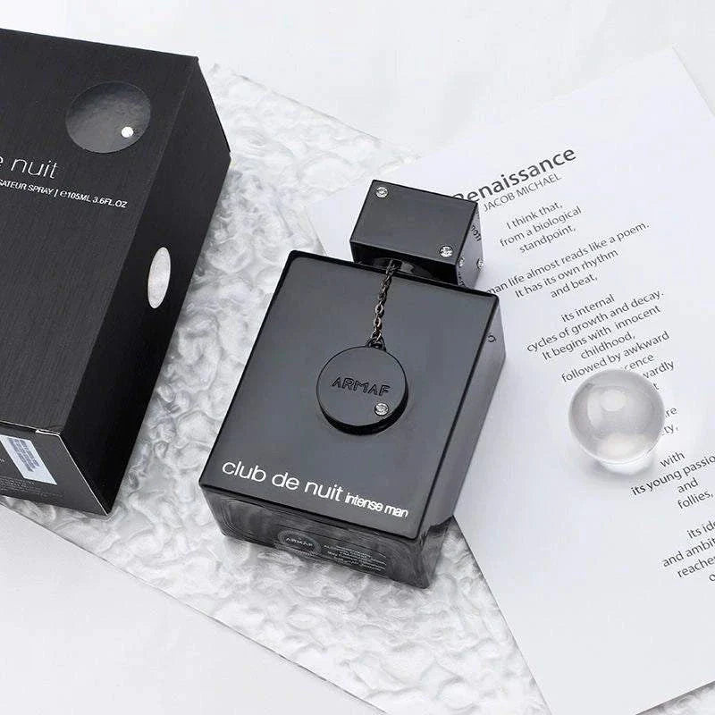 Armaf Club De Nuit intense men perfume bottle with black packaging on textured surface